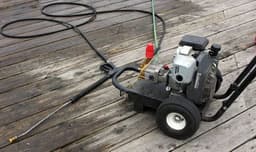 Pressure washer spraying water on a driveway